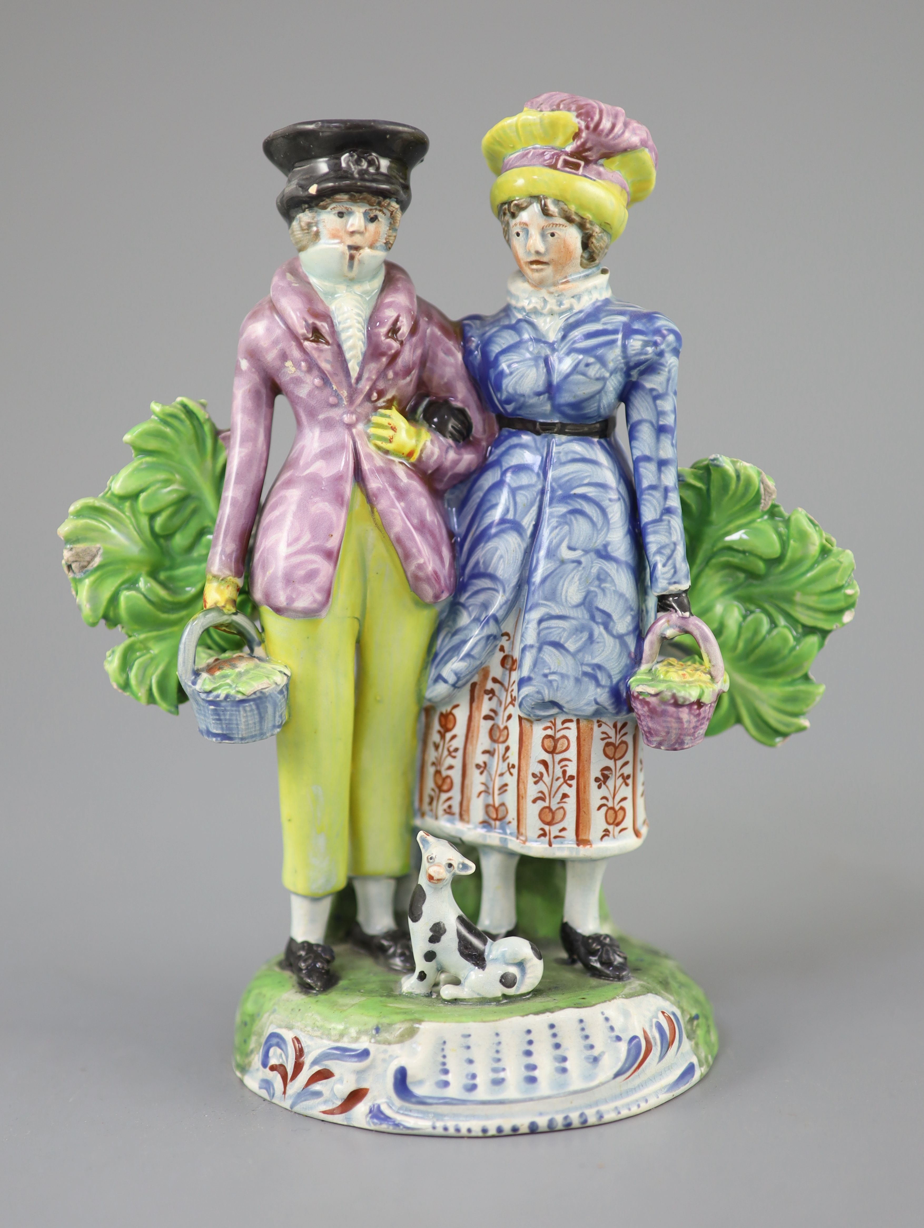 A Staffordshire pearlware group of a Dandy and Dandizette with seated dog, c.1820-30, 18cm high